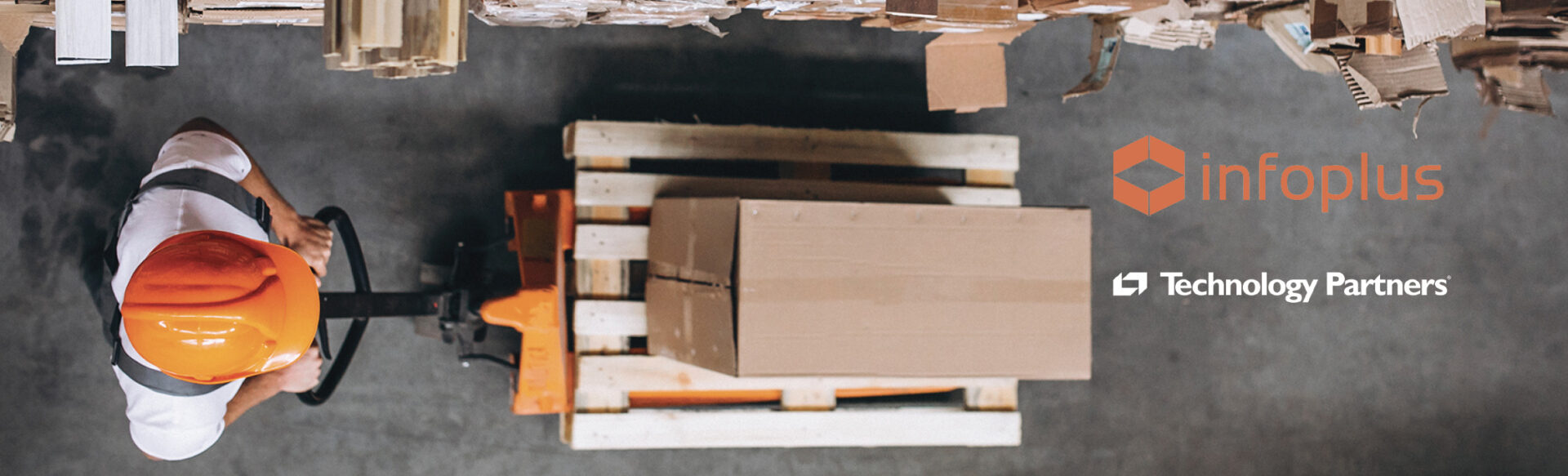 a man wearing an orange hard hat is pushing a pallet with a box on it and the words infoplus technology partners below him