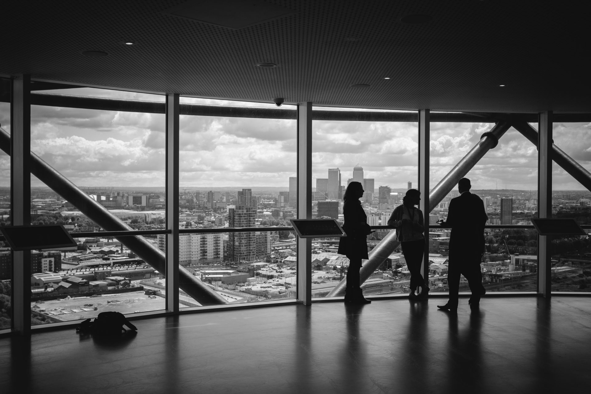 3 people discussing something in a building overlooking the city