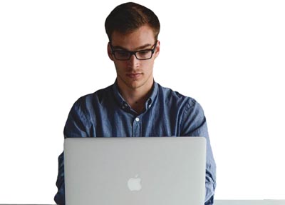 man in glasses working on a laptop computer